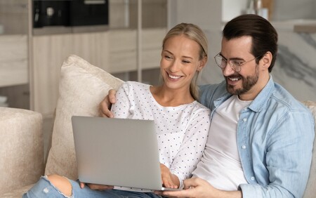 happy couple looking at laptop